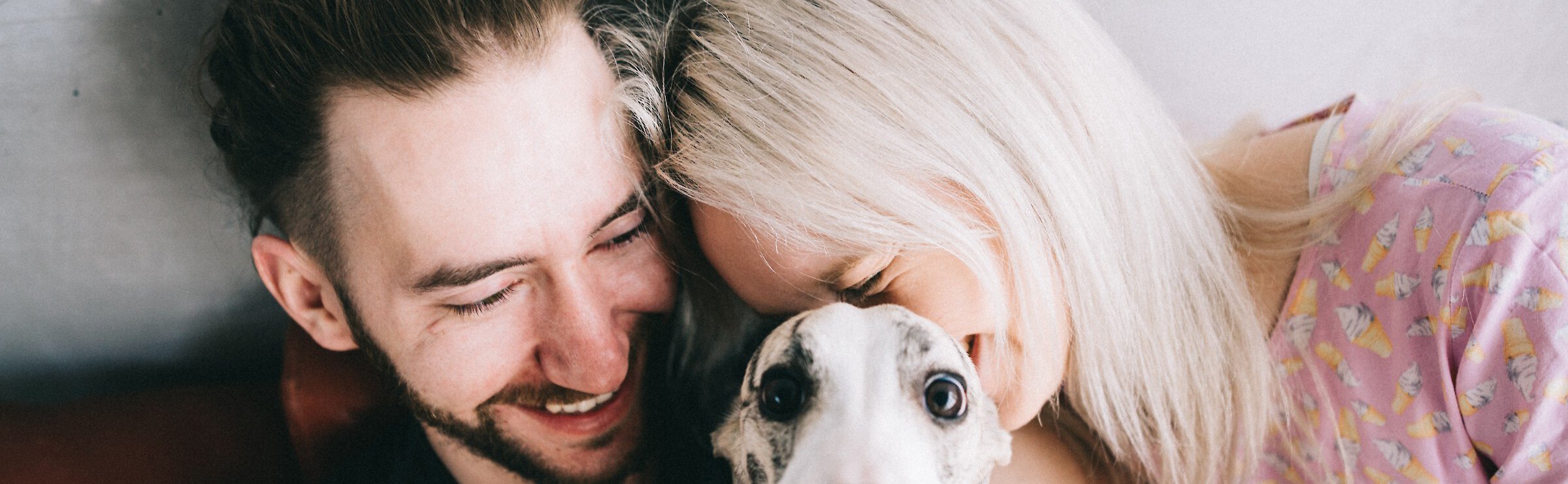Couple smiling while holding a dog