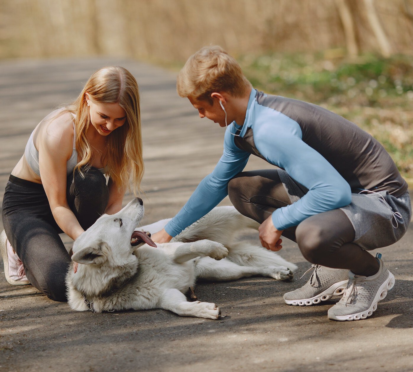 Couple taking a break on their run to scratch their dog